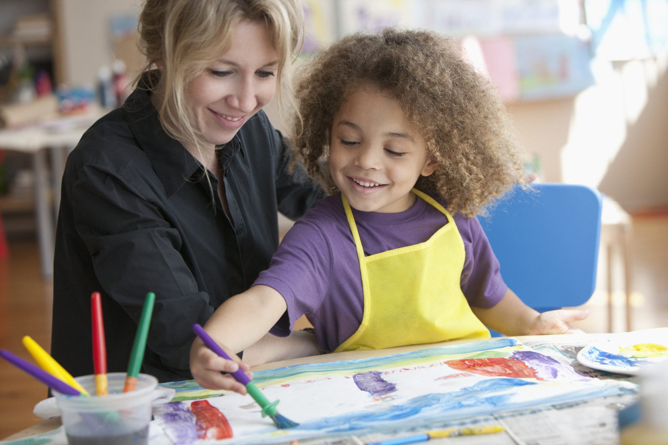 Child enjoying an art class with an educator